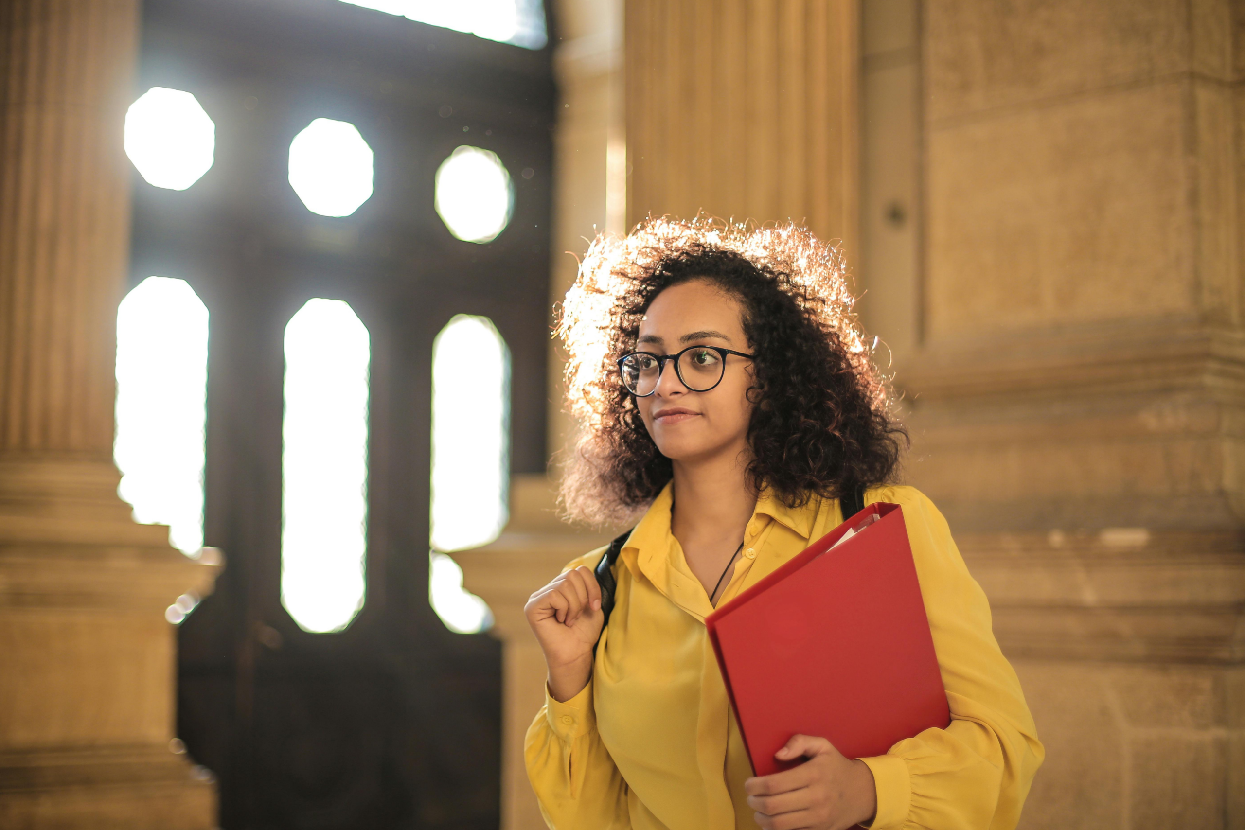 Une future étudiante universitaire sourit sur un campus, venue apprendre le français à Lyon pour atteindre le niveau B2